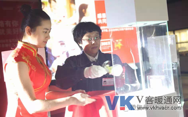 丹佛斯标准和产品认证经理的安金改女士身着工服将手中的一支金光闪闪的T2热力膨胀阀郑重地安放到展柜的中央 丹佛斯标准和产品认证经理的安金改女士身着工服将手中的一支金光闪闪的T2热力膨胀阀郑重地安放到展柜的中央
